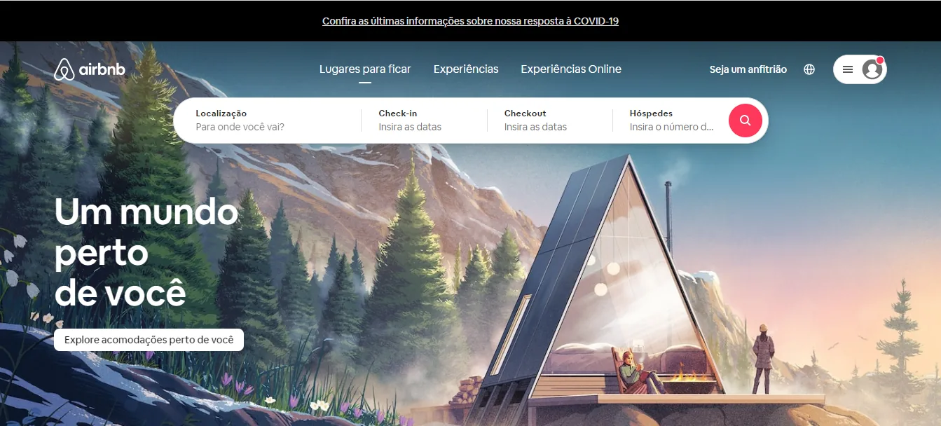 Página inicial do Airbnb com o título Um mundo perto de você, o botão Explore acomodações perto de você e a ilustração de uma cabana na montanha